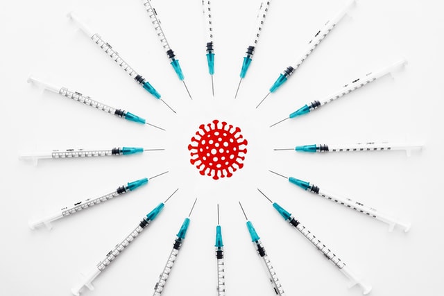 Syringes with needles surrounding virus